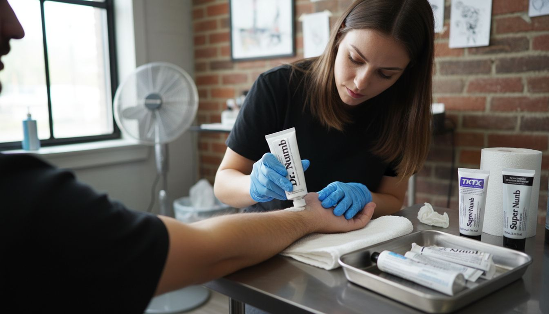 Artista del tatuaje aplicando crema anestésica sobre el antebrazo de su cliente