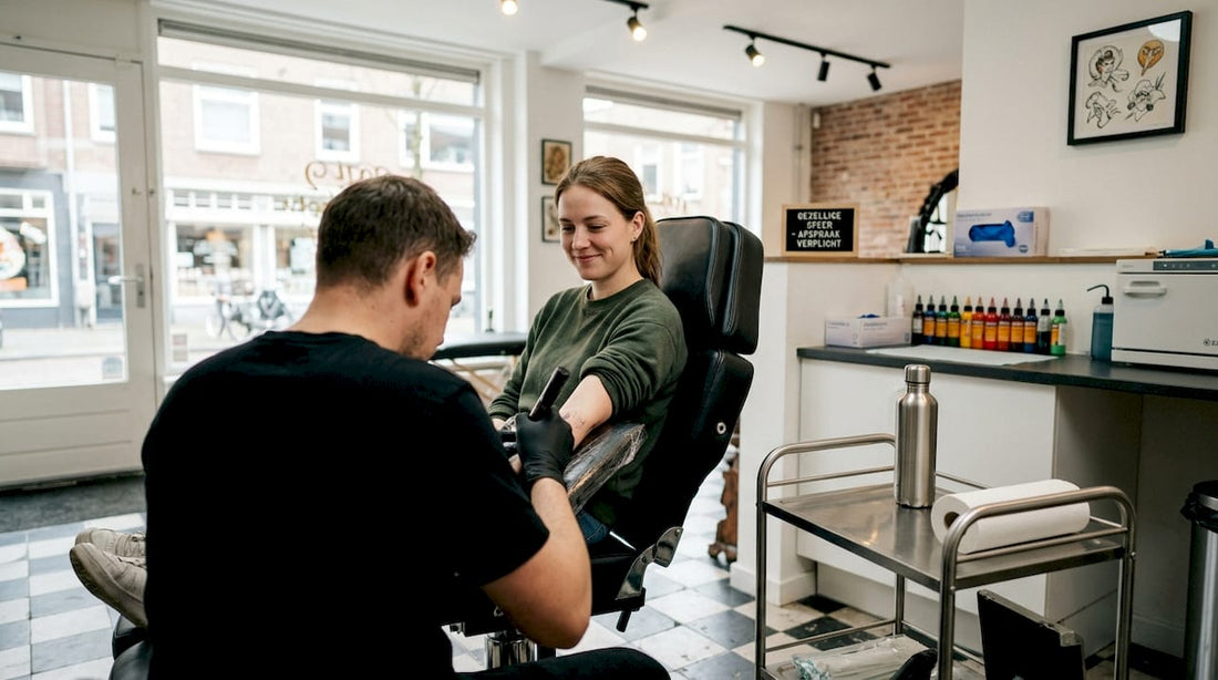 De klant zit ontspannen in de stoel terwijl de tattoo gezet wordt.
